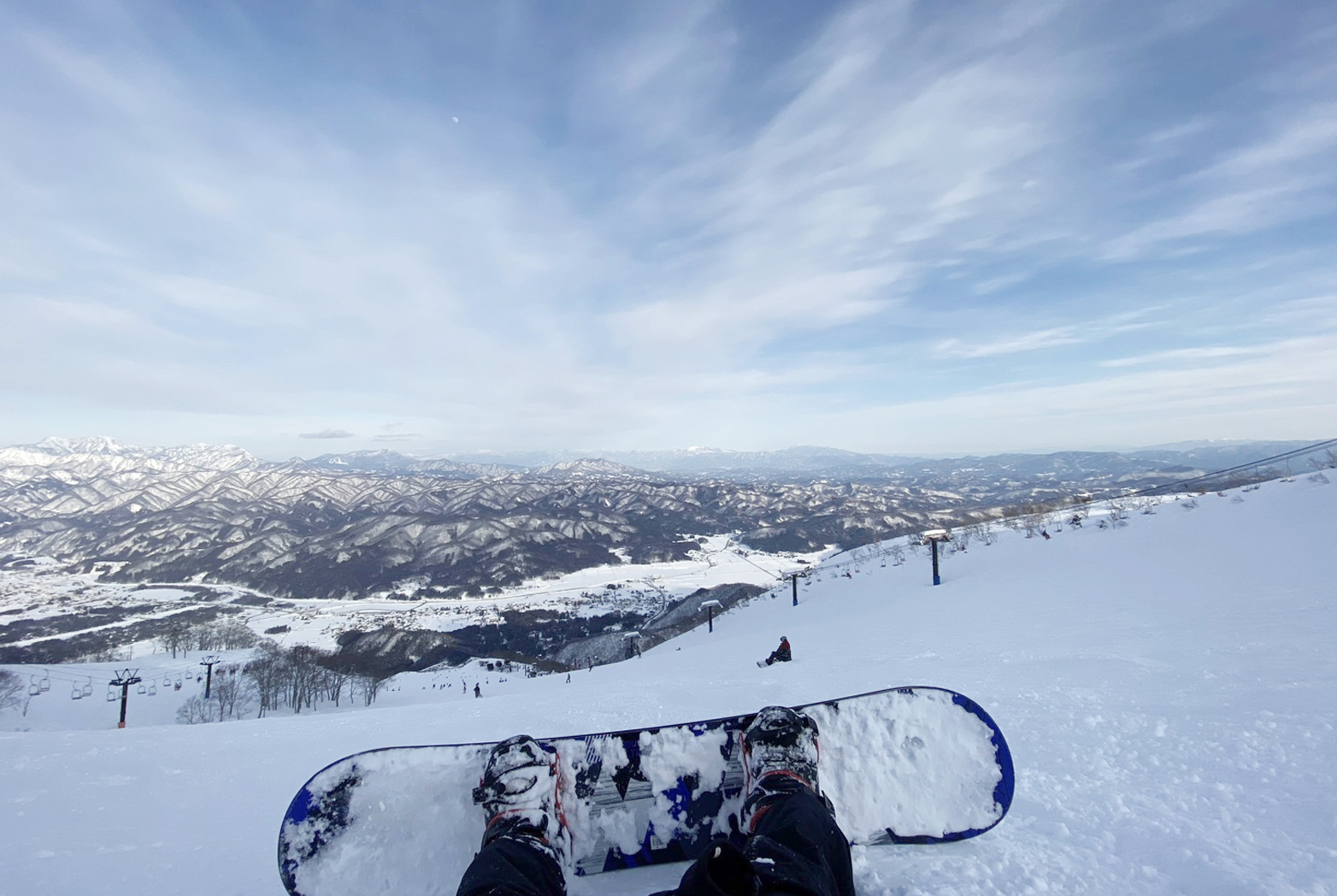 白馬の雪山でスノーボードを楽しみながら、広い山並みを見渡す景色