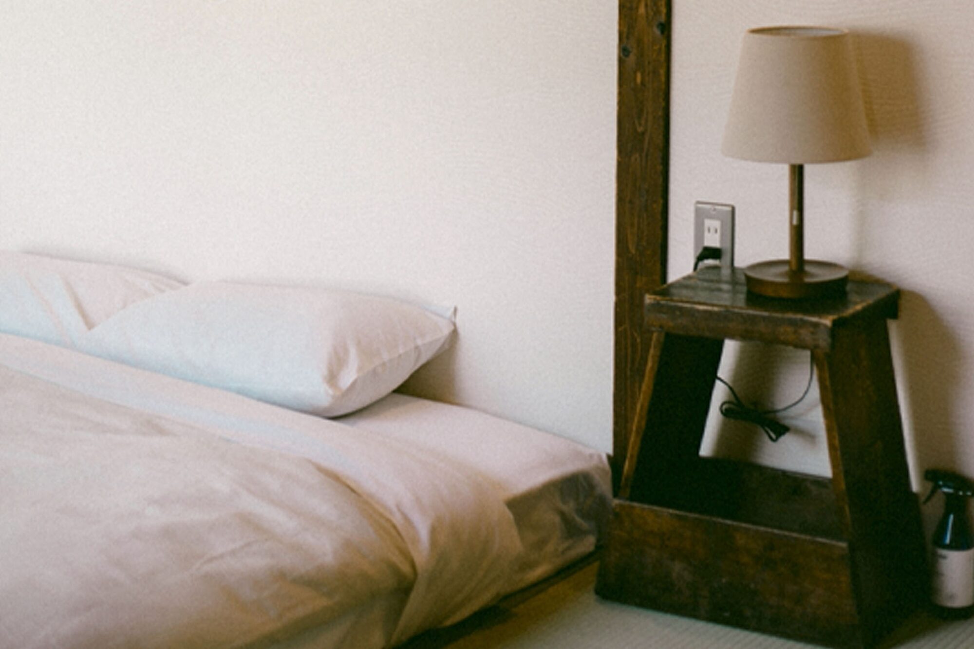 照明とサイドテーブルのあるベッド横