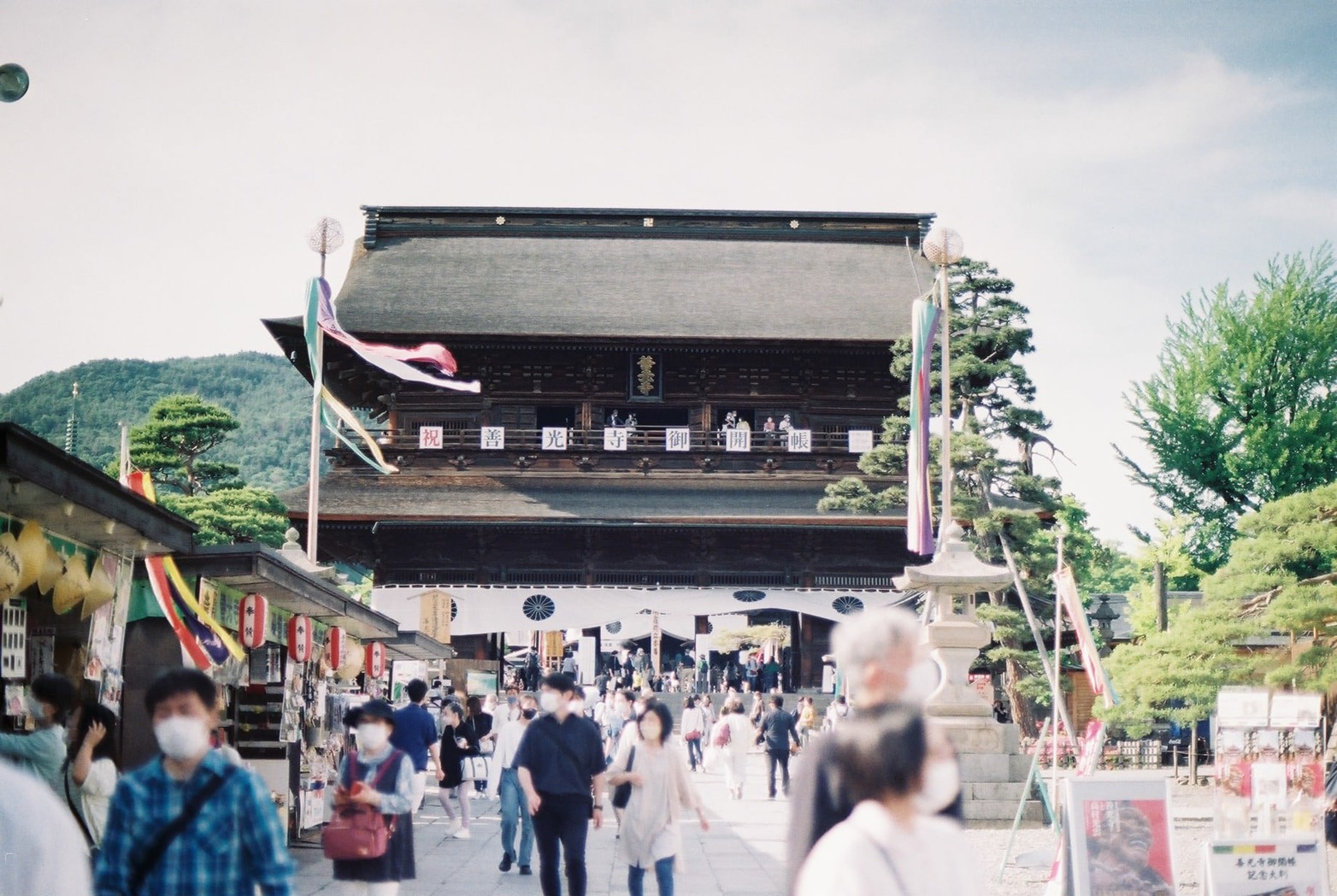 参道の先に善光寺本堂が見え、門前を多くの参拝客が行き交う風景